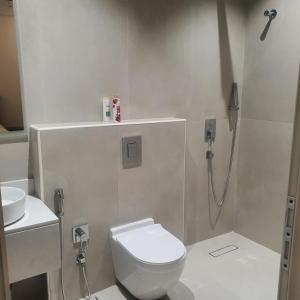 a white bathroom with a toilet and a shower at شقة مفروشة in Al Khobar