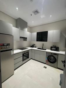 a large kitchen with white cabinets and a dishwasher at شقة مفروشة in Al Khobar +1 photo