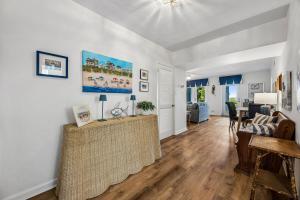 a living room with white walls and wooden floors at Dog Friendly Ground Level Duplex in Fernandina Beach