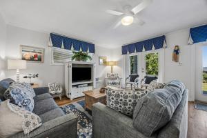 a living room with two couches and a tv at Dog Friendly Ground Level Duplex in Fernandina Beach