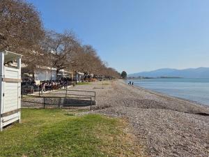 a beach with a group of people sitting on it at Lena's Nest Nafpaktos in Nafpaktos +5 photos