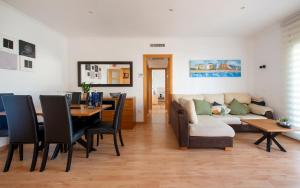 a living room with a couch and a table with chairs at BONITO APARTAMENTO in Sitges