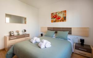 a bedroom with a bed with towels on it at BONITO APARTAMENTO in Sitges