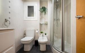 a white bathroom with a toilet and a shower at BONITO APARTAMENTO in Sitges +33 photos