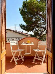 a patio with a table and chairs on a balcony at Joe's apartments in Carrara