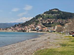 a beach with a town on top of a mountain at Lena's Nest Nafpaktos in Nafpaktos