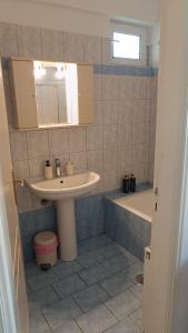 a bathroom with a sink and a bath tub at Lena's Nest Nafpaktos in Nafpaktos