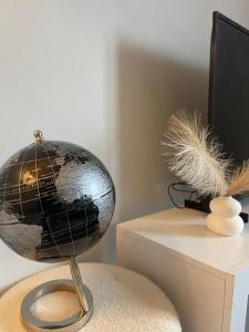 a globe sitting on a chair next to a television at Wilsuel Haven-2Bedroom Aprt in Wolverhampton +12 photos