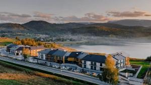 an aerial view of a building with a river and mountains at Lake Hill Studio 35- strefa wellness w cenie in Sosnówka