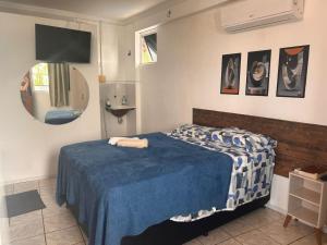 a bedroom with a bed with a blue blanket at Condomínio Boa Ideia apart completo ao lado North Shopping Maracanaú in Maracanaú