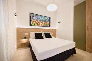 a bedroom with a white bed with a painting above it at Pilone del Monaco - Pool & Free Parking in Vieste +51 photos