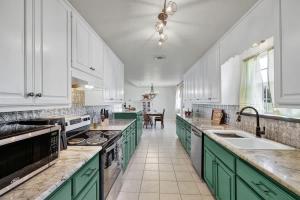 a kitchen with green and white cabinets and counters at Casa Blanca: Hot-tub, Fire Pit, Hill Country Views in Luckenbach