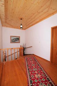 a room with a rug on the floor and a wooden ceiling at Hotel Brahimi in Gjirokastër