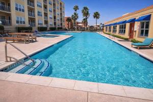 a swimming pool in a hotel with a table and chairs at Great Pool - Beach Access - Small Family Perfect in South Padre Island