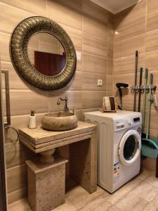 a bathroom with a sink and a washing machine at SeaLaVie - Summerland Mamaia in Mamaia