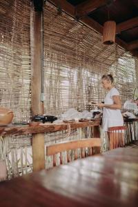 a woman standing in a kitchen with a cell phone at Pousada Jardim do vento in Icaraí