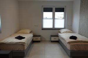 two beds in a room with two windows at Hotels-in-Alsdorf in Alsdorf