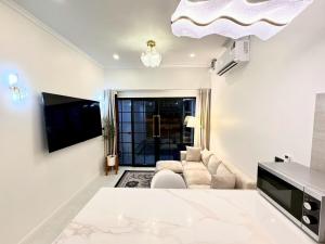 a white living room with a couch and a tv at pp villa phatthalung in Phatthalung