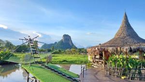 a boat with a ladder and a hut on a river at pp villa phatthalung in Phatthalung