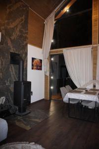 a living room with a stone fireplace and a tv at Vistachalet in Yablunytsya