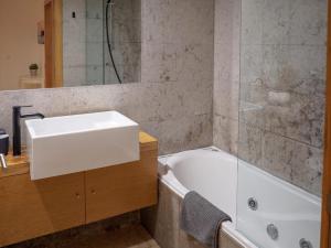 a bathroom with a white sink and a tub at Patio by the sea in Cruz Quebrada +39 photos