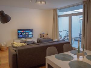 a living room with a couch and a tv at Patio by the sea in Cruz Quebrada