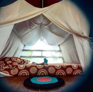 a bed in a tent with a window at Paraisurf colombia in Nuquí