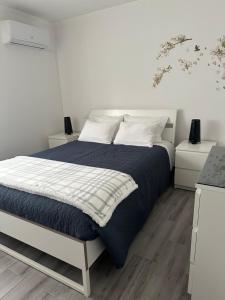 a bedroom with a bed with a blue blanket and white pillows at Terraço d’Aldeia in São Pedro do Sul