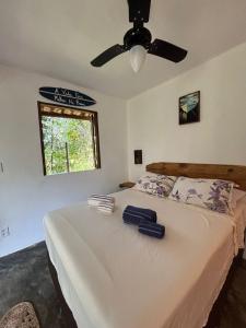a bedroom with a bed with a ceiling fan at CASA NANDOS Studio quintal da mata !!! in Itacaré