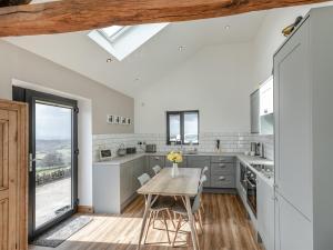 a kitchen with a table and chairs and a window at Shutlingsloe in Mellor