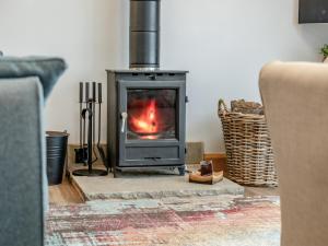 a stove in a living room with a fireplace at Shutlingsloe in Mellor