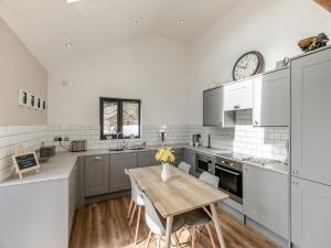 a kitchen with a table and a clock on the wall at Shutlingsloe in Mellor