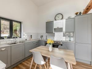a kitchen with a table and chairs and a clock at Shutlingsloe in Mellor +32 photos