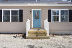 a house with a blue door and stairs in front at Maine Woods Retreat in Ellsworth