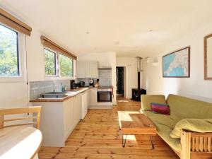 a kitchen and living room with a couch and a table at Foxglove cabin in Bodmin