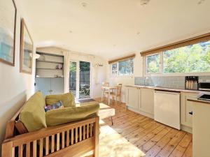 a living room with a couch and a kitchen at Foxglove cabin in Bodmin