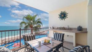 a balcony with a table and a view of the ocean at Vacation Paradise Relaxing Ocean Front Condo in Puerto Peñasco