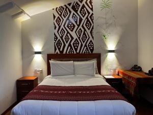 a bedroom with a large bed with two night stands at Casa Antade Cusco in Cusco