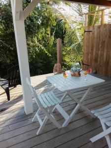 a picnic table and a chair on a deck at Tialba Lodge in Sainte-Anne