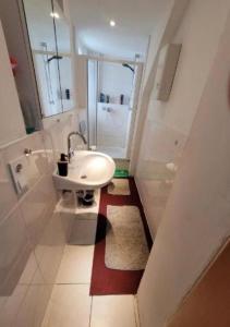 a white bathroom with a sink and a window at Monteurzimmer/Ferienwohnung/Pension in Siegen