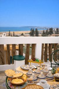 a table filled with plates of food on a balcony at Riad Chama in Essaouira
