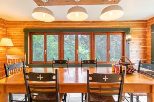 a dining room with a wooden table and chairs at La Vieille École & Spa & Parc Naturel in West Brome