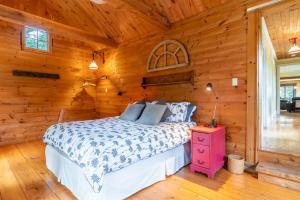 a bedroom with a bed in a log cabin at La Vieille École & Spa & Parc Naturel in West Brome +30 photos