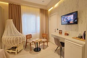 a hotel room with a table and a tv on the wall at Lavender Inn Hotel in Arnavutköy