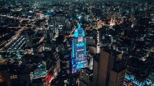 a view of the empire state building lit up at night at Hotel Normandie - by Easy Hotéis in São Paulo