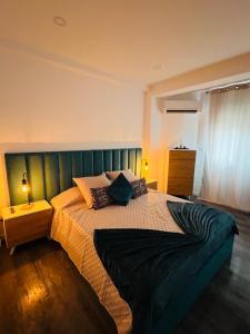 a bedroom with a large bed with a green headboard at House Caparica in Costa da Caparica