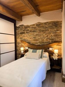 a bedroom with a stone wall and a bed at A Casa da Ponte in Lugo