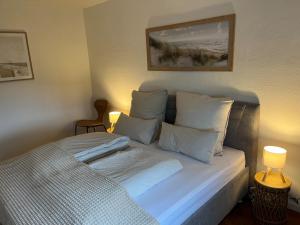 a bed with white sheets and pillows in a room at Auszeit im alten Land 2 in Buxtehude