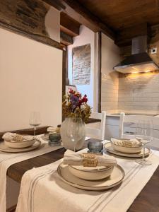 a dining room with a table with a vase of flowers at A Casa da Ponte in Lugo