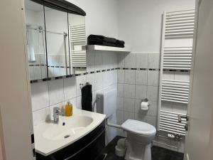 a white bathroom with a sink and a toilet at Auszeit im alten Land 2 in Buxtehude +8 photos